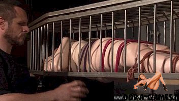 A caged slave gets strapon anal sex